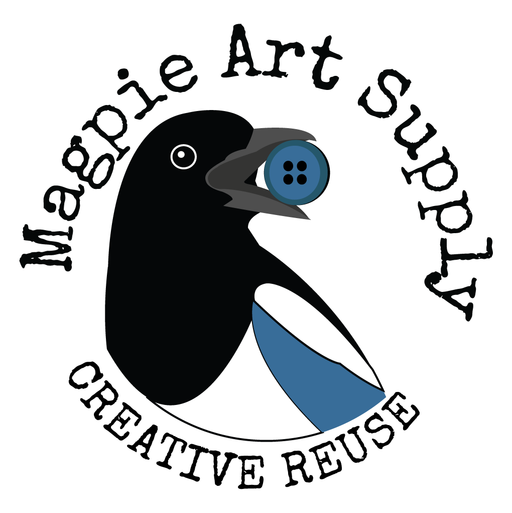 Magpie Art Supply logo is a magpie's black, white, and blue head and upper body looking to the right and holding a paint brush in its open beak
